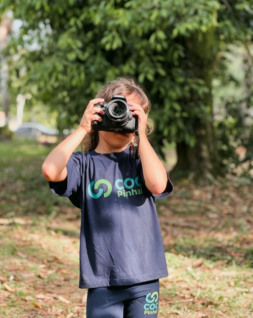 Aluno dos Anos Iniciais fotografando no pátio